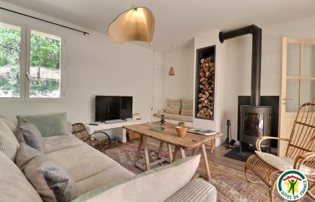 Le salon, avec un grand canapé, une banquette et un fauteuil en rotin années 60 chiné Gite n°G102009 Condillac - Drôme - Le salon, avec un grand canapé, une banquette et un fauteuil en rotin années 60 chiné
